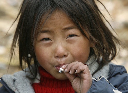 A child smokes a cigarette at Dayingpan Village in Sichuan province.