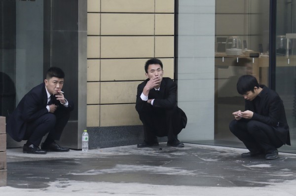 Employees smoke outside an office building in Beijing. This will become an increasingly common site once the new anti-smoking law is passed in China. 