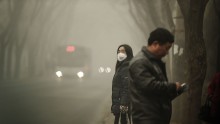 A woman covers her mouth and nose as a protective measure against the smog