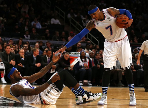 New York Knicks forward Carmelo Anthony (R) helps up Cleveland Cavaliers' LeBron James during an NBA All-Star Game