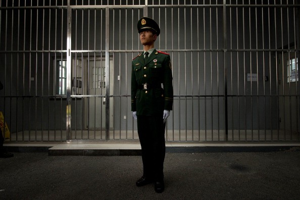 A Chinese paramilitary police man stands guard outside a prison entrance (Getty Images)