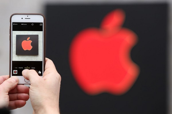 A visitor photographs a red Apple logo with an iPhone at the Apple Store on Dec. 1, 2014 in Berlin, Germany.
