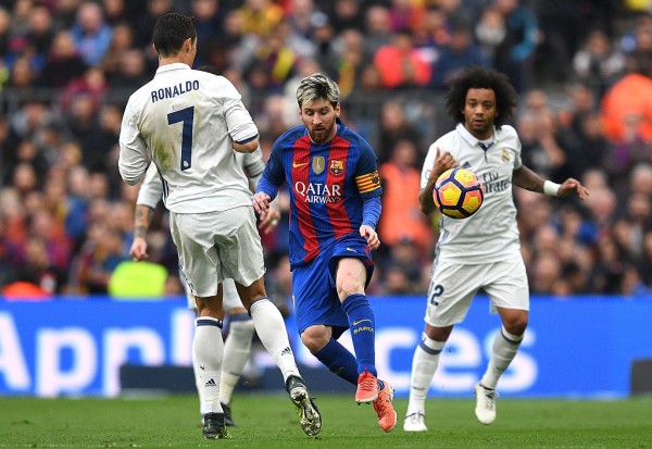 Barcelona forward Lionel Messi (middle) is surrounded by Real Madrid players Cristiano Ronaldo, Sergio Ramos, and Marcelo (R)