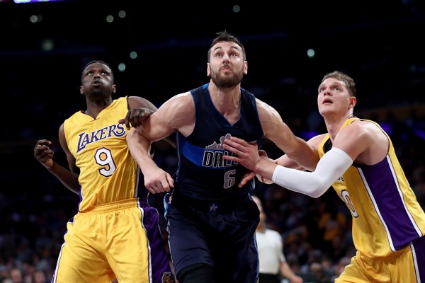 Dallas Mavericks center Andrew Bogut (middle) competes for the rebound against two Los Angels Lakers players