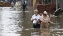A couple wades through floodwater in Lahore after torrential rains ravaged Pakistan, India and parts of China.
