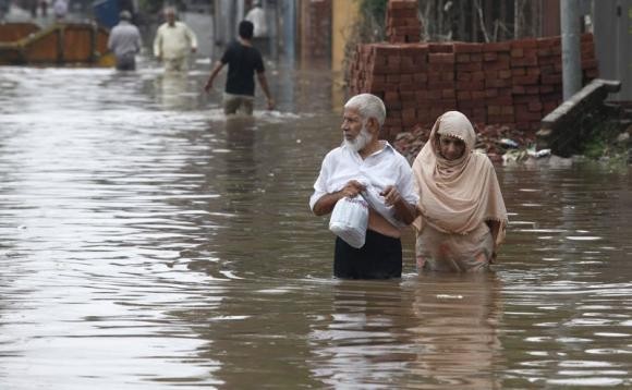 A couple wades through floodwater in Lahore after torrential rains ravaged Pakistan, India and parts of China.