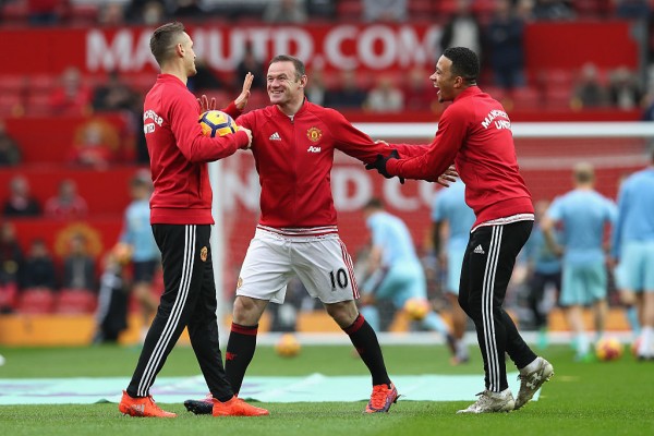 Morgan Schneiderlin (L) and Memphis Depay play with Manchester United captain Wayne Rooney (middle)