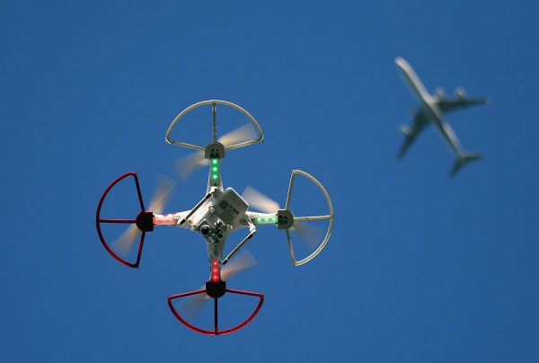 A drone is flown for recreational purposes as an airplane passes nearby in the sky above Old Bethpage, New York on September 5, 2015.