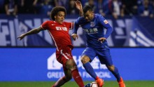 Tianjin Quanjian midfielder Axel Witsel (L) competes for the ball against Shanghai Shenhua's Carlos Tevez