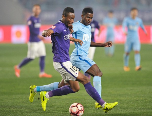 Tianjin Teda midfielder John Obi Mikel (L) competes for the ball against Jiangsu Suning's Ramires