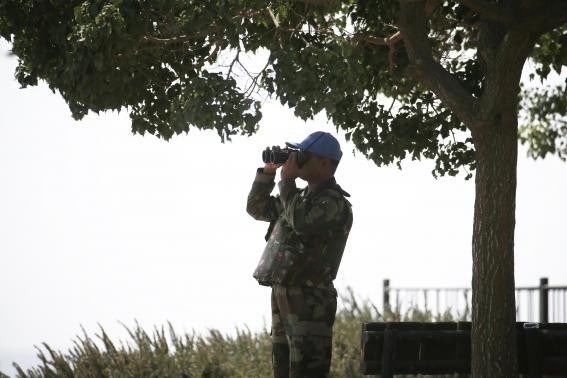 An UNDOF peacekeeper looks at the Syrian side of the crossing from the Israeli-administered Golan Heights on September 1, 2014.