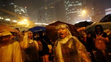 Protesters on Sept. 30 stand in the rain while blocking areas around Hong Kong's  government headquarters building, 
