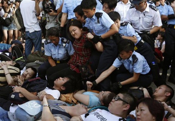 Police drag a protester on a street outside HSBC's headquarters at Hong Kong's financial Central district on July 2, 2014.