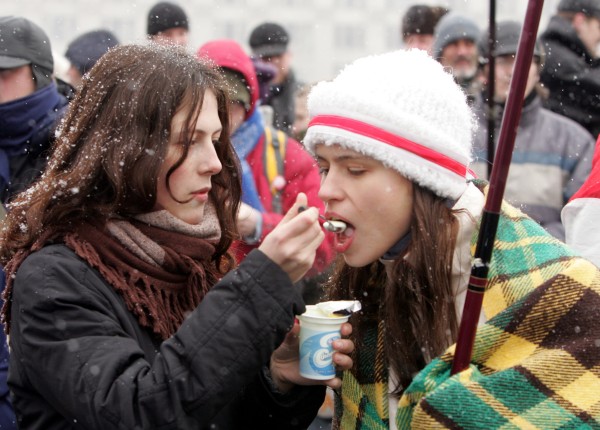 Supporters of opposition presidential candidate Alexander Milinkevich share a yogurt