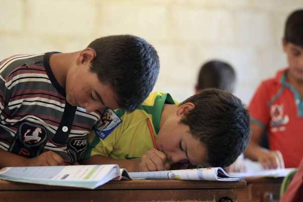 Children attend a class during the first day of school in Idlib countryside September 11, 2014.