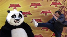 Jack Black performs a kick as he poses with ''Po''