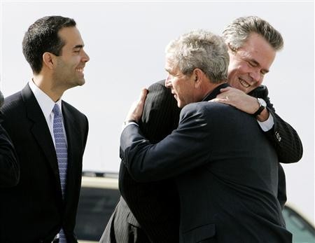 George P. Bush (L) looks on as his uncle then-President George W. Bush (C) hugs his father ex-Florida Gov. Jeb Bush (R) in Palm Beach, Florida, March 18, 2008.
