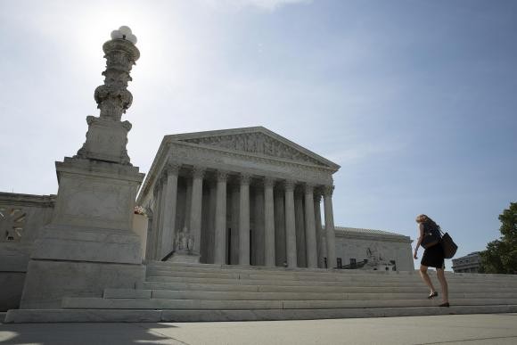 A woman walks to the Supreme Court in Washington in this June 19, 2014 file photo.