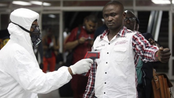  Nigerian port health official uses a thermometer on a worker at the arrivals hall of Murtala Muhammed International Airport in Lagos. 