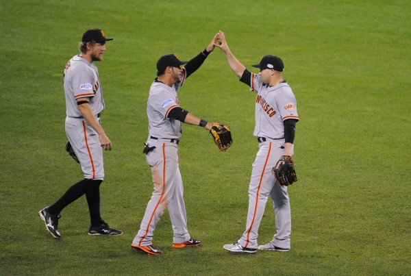 Oct 21, 2014; Kansas City, MO, USA; San Francisco Giants outfielders Gregor Blanco (middle) , Hunter Pence (left) and Juan Perez (right) celebrate after defeating the Kansas City Royals during game one of the 2014 World Series at Kauffman Stadium. 