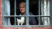 Sidney Shapiro, then 84, looks through the window of his apartment in an ancient courtyard house in central Beijing in this September 13, 1999 file picture. Shapiro, a famed US-born translator who was one of the few Westerners to gain Chinese citizenship 