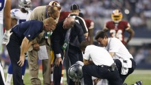 ct 27, 2014; Arlington, TX, USA; Dallas Cowboys quarterback Tony Romo (9) lays on the field injured as trainers, doctors and head coach Jason Garrett check on him in the this quarter against the Washington Redskins at AT&T Stadium. 