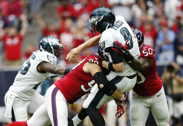 Nov 2, 2014; Houston, TX, USA; Philadelphia Eagles quarterback Nick Foles (9) is tackled by Houston Texans defensive end J.J. Watt (99) and linebacker Akeem Dent (50) during the first quarter at NRG Stadium. 