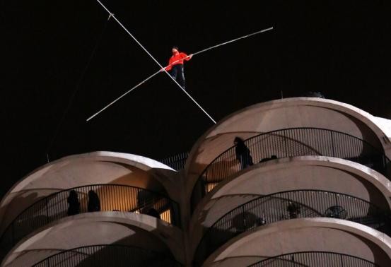 Daredevil Nik Wallenda walks along a tightrope between two skyscrapers suspended 500 feet above the Chicago River in Chicago, Illinois, November 2, 2014.