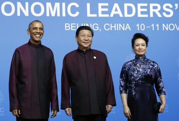 U.S. President Barack Obama (L) poses for photographs with China's President Xi Jinping (C) and Xi's wife Peng Liyuan during the APEC Welcome Banquet at Beijing National Aquatics Center, or the Water Cube, in Beijing, November 10, 2014.