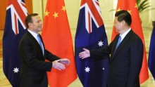 Chinese President Xi Jinping (right) extends his hand to greet Australian Prime Minister Tony Abbott before a meeting at the Great Hall of the People in Beijing on April 11, 2014.