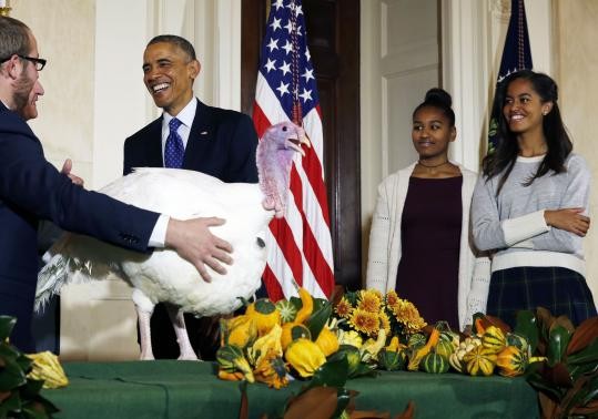 U.S. President Barack Obama and his daughters, Sasha (C), and Malia (R), participate in the annual turkey pardoning ceremony marking the 67th presentation of the National Thanksgiving Turkey.