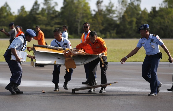 Indonesian Airforce personnel carry suspected debris