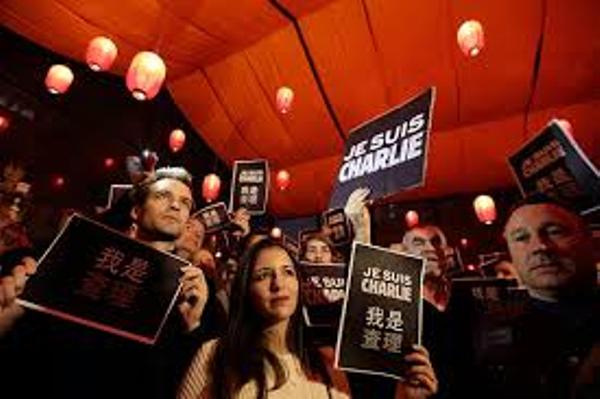 Beijing Police monitor Chinese and foreign reporters at a large gathering for Charlie Hebdo massacre victims