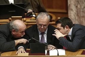 Greek Prime Minister Alexis Tsipras (R) speaks with Deputy Prime Minister Giannis Dragasakis (C) and Interior and Administrative Reconstruction Minister Nikos Voutsis before Tsipras' first major speech in parliament in Athens February 8, 2015. 