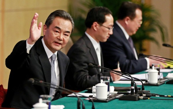 Chinese Foreign Minister Wang Yi (L) waves at a news conference at the National People's Congress. March 8, 2015. 