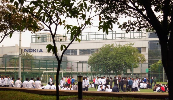 File photo. Factory workers hold protest against backdrop of Nokia factory in Guandong, China. 