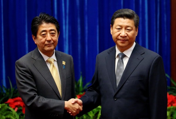 China's President Xi Jinping (R) shakes hands with Japan's Prime Minister Shinzo Abe at APEC meetings in Beijing, Nov. 10, 2014.