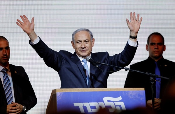 Israeli Prime Minister Benjamin Netanyahu waves to supporters at the party headquarters in Tel Aviv March 18, 2015. 