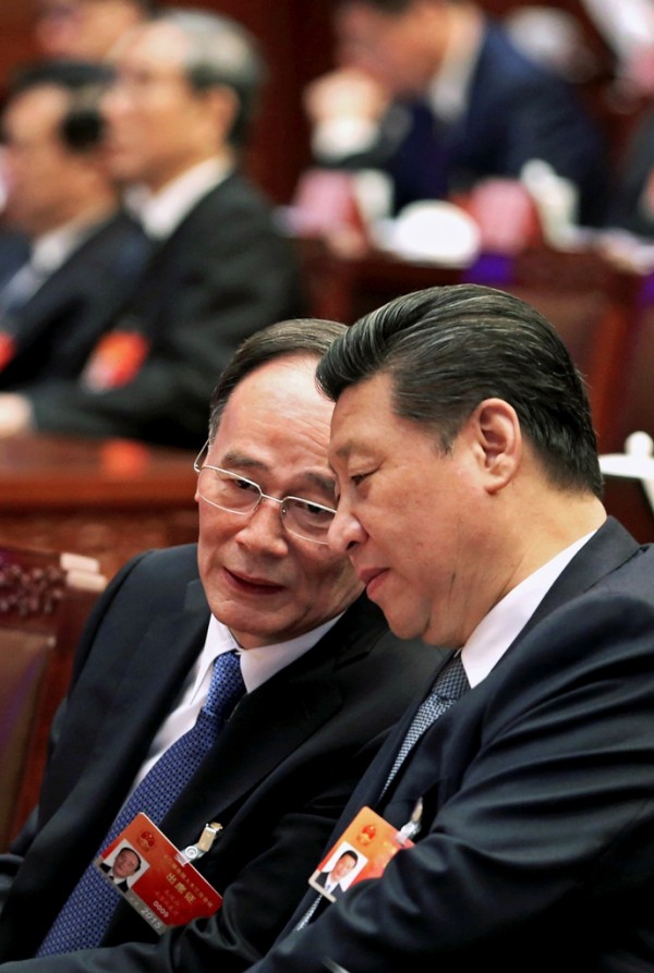 China's President Xi Jinping (R) speaks to Wang Qishan, a member of the Standing Committee of the Political Bureau of the Communist Party of China (CPC). Beijing, March 4, 2015.
