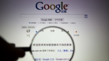 A person poses with a magnifying glass in front of a Google search page in this illustrative photograph. Google Inc moved its China search service to the more free environment of Hong Kong 