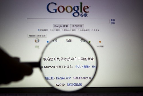A person poses with a magnifying glass in front of a Google search page in this illustrative photograph. Google Inc moved its China search service to the more free environment of Hong Kong 