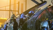 Rescue workers climb into the wreckage of a derailed Amtrak train to search for victims in Philadelphia, Pennsylvania May 12, 2015.
