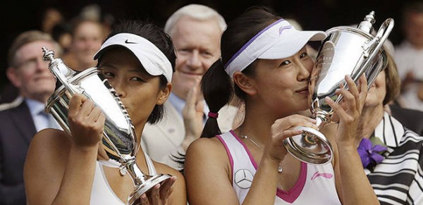 Peng Shuai and Hsieh Su-wei kissing their Wimbledon trophies