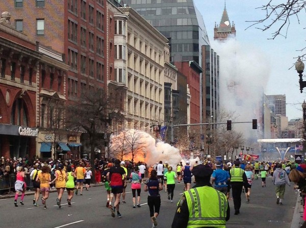 Runners continue to run towards the finish line of the Boston Marathon as an explosion erupts near the finish line of the race in this photo exclusively licensed to Reuters by photographer Dan Lampariello after he took the photo in Boston, Massachusetts, 