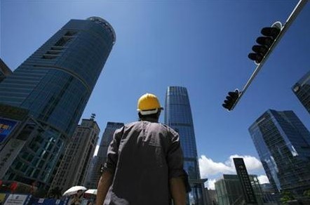 A construction worker crosses a street at a business district in Shenzhen, China's southern Guangdong province July 16, 2009.