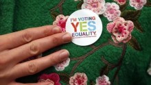 A Yes supporter shows of her campaign badge in central Dublin