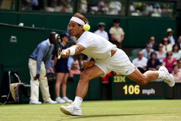 Rafael Nadal reaches for a backhand in an a match at the 2014 Wimbledon Championships