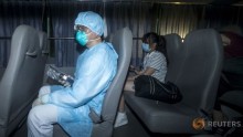 A health worker wears a protective suit while sitting with people who came in close contact with the Korean Mers patient.
