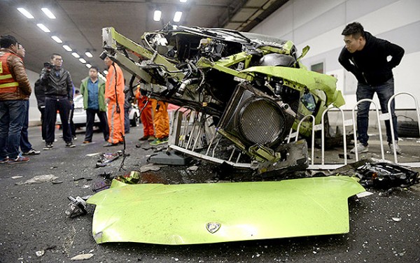 A man looks inside a damaged Lamborghini