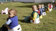 Children of Colombians working in a farm that grows flowers for export take a group lesson in potty-training 